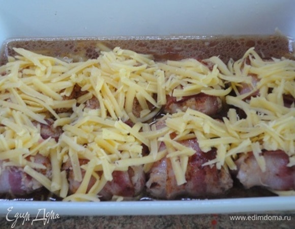 В сковороду, где обжаривались фрикадельки, влить вино, довести до кипения и вылить в форму с фрикадельками. Сверху фрикадельки посыпать сыром и запекать 20–25 минут в духовке при 180°C.