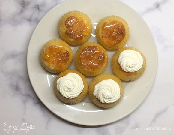 Делаем крем. Взбиваем сливки, затем добавляем сахарную пудру и творожный/сливочный сыр. Перемешиваем до однородности и перекладываем в кондитерский мешок. Булочки переворачиваем, чтобы низ оказался сверху, и отсаживаем на него шапочку из крема.