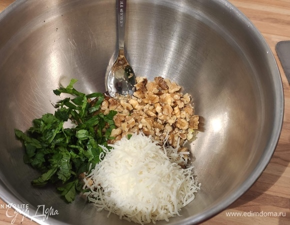 Очистить и очень мелко нарезать чеснок. Очистить перец чили, разрезать вдоль, вымыть и удалить семена. Стручок нарезать небольшими кусочками. Количество чили регулируйте по своему вкусу. Нарезать петрушку. Отложить немного нарезанной петрушки для подачи. Крупно порубить грецкие орехи. Пармезан натереть на мелкой терке. Смешать в большой миске чеснок, перец чили, петрушку, грецкие орехи, пармезан и тмин. Приправить солью и перцем.