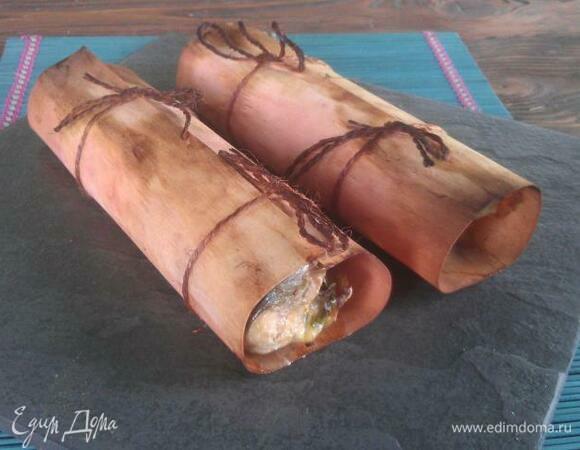 Лист гриль-бумаги отряхнуть от вина и разрезать его ножницами на две равные части поперек волокон древесины. Смазать внутреннюю часть каждой половинки гриль-бумаги оливковым маслом и разложить на ней в центре кусочки лимона, фенхеля и цукини, сверху (вдоль волокон древесины) поместить замаринованную рыбу, завернутую в слегка смоченный в вине лист нори. Сверху положить кусочки лимона, фенхеля и цукини. Гриль-бумагу обернуть рулоном вокруг получившегося «сэндвича» из рыбы, лимона и овощей, обвязать двумя отрезками бечевки. Получившиеся рулоны уложить на предварительно нагретое блюдо для запекания так, чтобы шов оказался снизу; установить в духовку.