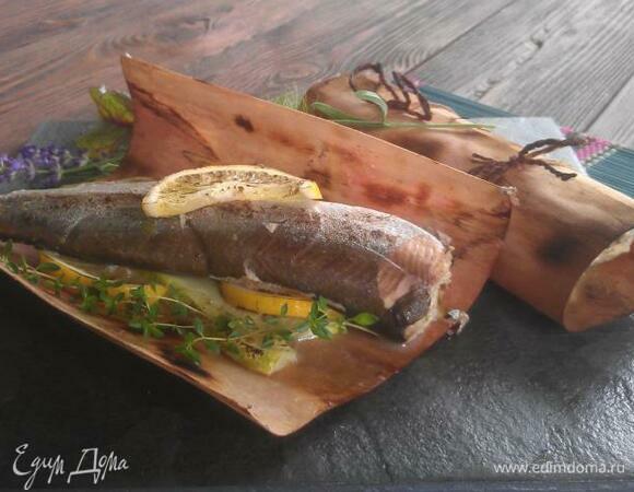 Запекать 10–12 минут. За это время гриль-бумага медленно тлеет, рыба насыщается ароматами овощей и приправ, цитрусовых и вина, а также ароматом морских водорослей и копченостью ольхи (дуба) и при этом получается очень сочной. Вместо редкого гольца можно использовать любую рыбу семейства лососевых: форель, стейки семги. Впрочем, и белую бескостную рыбу — судака, сома и даже севрюгу — можно с успехом приготовить по этому рецепту. Овощи и цитрусовые к рыбе также можно подобрать по собственному вкусу.