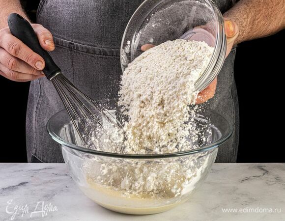 Всыпьте муку и замесите тесто. Накройте его пищевой пленкой и уберите в теплое место на 40 минут.
