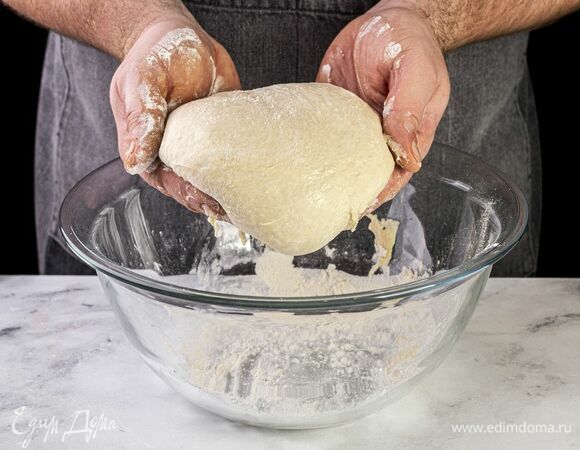 На припыленной мукой поверхности раскатайте подошедшее тесто в круг толщиной 3 мм, сформируйте небольшие бортики.
