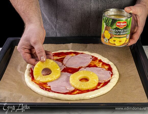 Откройте банку с ананасами Del Monte (435 г) и слейте сок. На тесто выложите ветчину и ананасы.