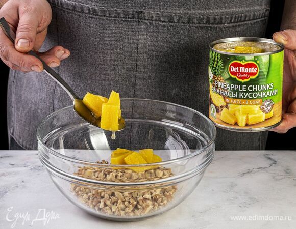 Откройте банку с ананасами Del Monte (435 г), слейте сок и выложите кусочки ананаса в чашу к орехам.
