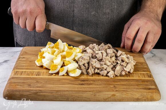 Добавьте нарезанные кубиком яйца и куриное филе.