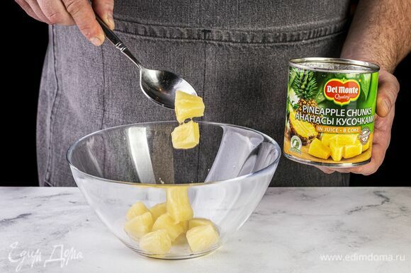 Откройте банку с ананасами Del Monte (435 г), слейте сок и выложите кусочки ананаса в глубокую миску.