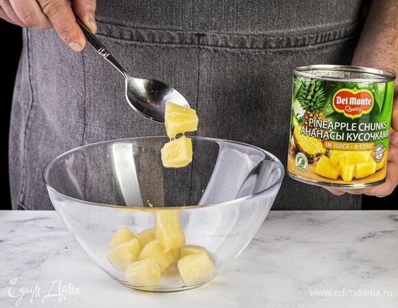 Откройте банку с ананасами Del Monte (435 г), слейте сок и выложите кусочки ананаса в глубокую миску.
