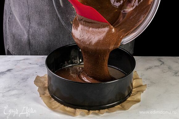 Форму для выпечки застелите пекарской бумагой, разогрейте духовку до 180°C. Выложите тесто для бисквита в форму и выпекайте в духовке 35 минут.
