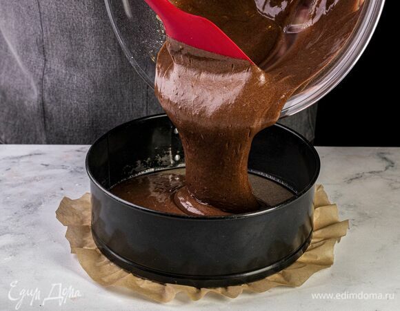 Форму для выпечки застелите пекарской бумагой, разогрейте духовку до 180°C. Выложите тесто для бисквита в форму и выпекайте в духовке 35 минут.