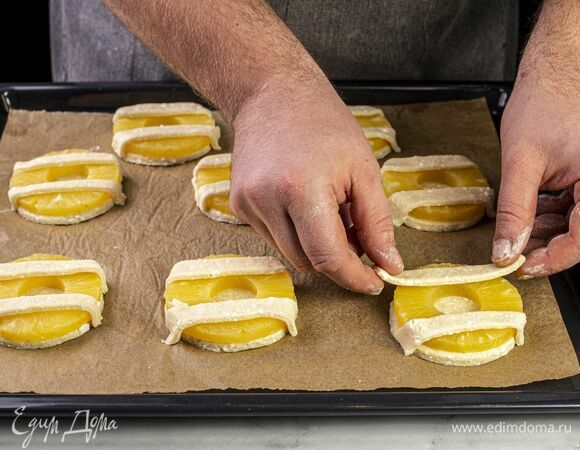 Из остатков теста сделайте красивую решетку при помощи кулинарного валика. Выложите поверх ананасов и прижмите снизу.