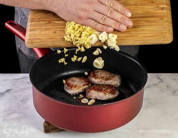 Филе свинины нарежьте небольшими стейками. Обжарьте на сковороде с добавлением растительного масла до полуготовности. Имбирь и чеснок очистите и измельчите, добавьте в сковороду.