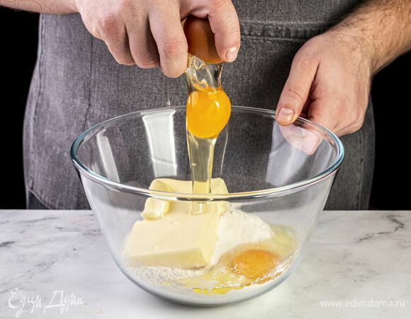 В глубокую миску насыпьте просеянную муку, добавьте размягченное сливочное масло и яйца.