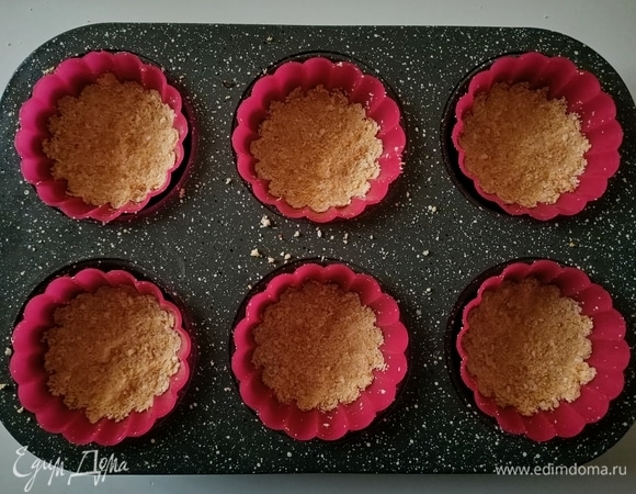 Печенье измельчить, добавить растопленное сливочное масло, перемешать. Выложить смесь в форму для маффинов, утрамбовать и поставить в холодильник.