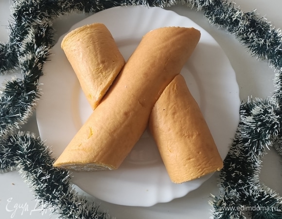 Уложить рулет на блюдо, по бокам выложить отрезанные кусочки, они будут имитировать сучки дерева.