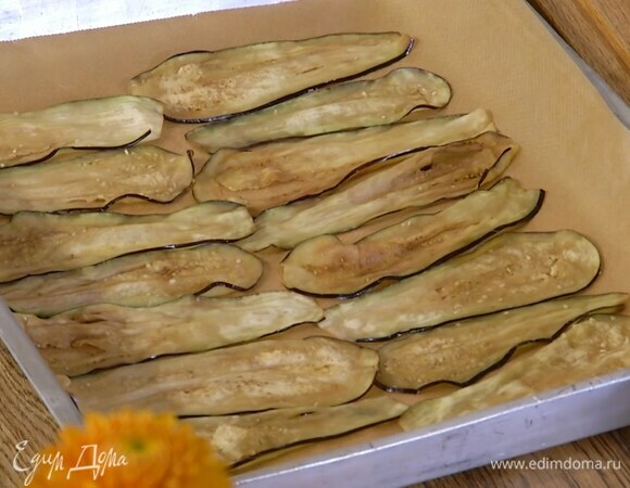 Противень выстелить бумагой для выпечки, выложить баклажаны в один слой, сбрызнуть их оливковым маслом, поперчить и отправить в духовку под разогретый гриль.