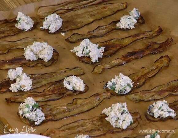 На край каждой полоски из баклажана выложить по чайной ложке творожной начинки и свернуть рулетиком.