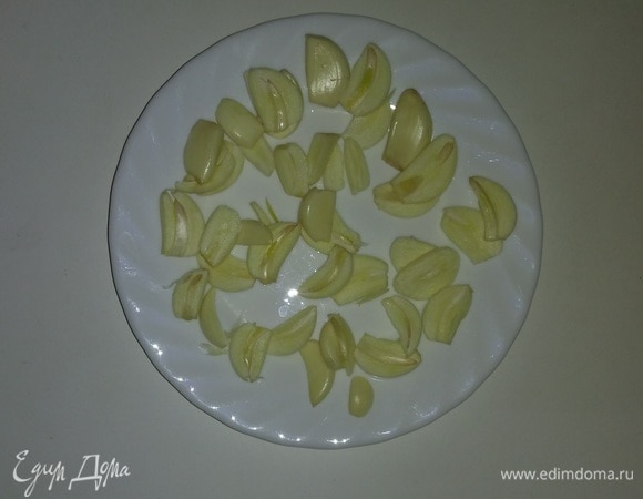 Очищенные дольки чеснока нарезать овальными кусочками толщиной около 1–2 мм.