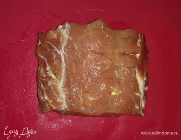 Затем начинить мясо чесноком. Для этого нужно достаточно часто проткнуть мясо ножом со всех сторон, кроме нижней, так как у моего куска мяса там находится жировая прослойка, на этой стороне мясо будет лежать при запекании. После чего вставляем в эти разрезы чесночные кусочки.