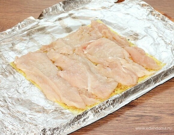 Выкладываем пластины курицы на бумагу и формируем прямоугольник.
