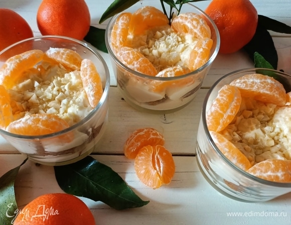 Сверху десерт посыпать рубленым миндалем и поставить в холодильник. Перед подачей украсить дольками мандарина. Приятного аппетита!