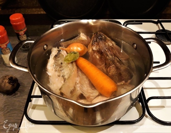 Пока рыба находится в холодильнике, готовим рыбный бульон. В кастрюлю наливаю 2 литра воды, укладываю суповые части рыбы, морковь, лук, перец. Варю после закипания минут 20. Вкусный рыбный бульон для заливного готов! Чтобы заливное получилось бордового цвета, в кастрюлю с бульоном положила нарезанную свеклу и немного проварила. Процедила, добавила желатин, хорошо размешала. Я пользуюсь желатином с приправами для рыбного заливного — в нем уже содержится соль. На 2 литра воды — 2 пакетика.