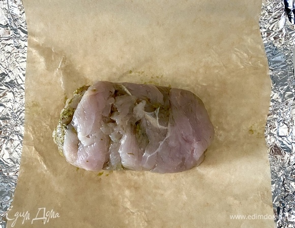 Снять пленку, выложить рулетик на пергамент и плотно завернуть в фольгу. Запекать при 200°C 30 минут.