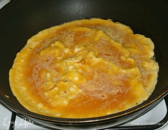 В сковороде разогреть растительное масло, вылить яичную массу и пожарить омлет. Сначала с одной стороны, затем перевернуть на другую сторону. Готовый омлет выложить на доску, застеленную бумагой или фольгой. Вырезать из омлета кружки такого же, как хлеб, размера.