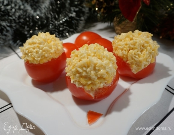 На помидорах сделайте треугольный вырез под бороду Дедов Морозов, чтобы майонез хорошо держался и не сползал. Заполните помидоры сырной смесью так, чтобы была горочка.