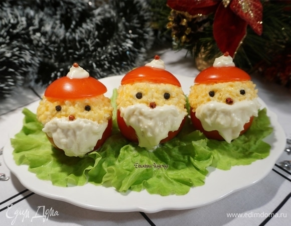 Накройте горочку отрезанной частью помидора. Теперь будем превращать помидоры в Дедов Морозов: из майонеза делаем бороды, из горошин перца — глаза и нос. Украшаем голову шапочкой помидора. Капля майонеза — это помпон с кисточкой из перца. Такие порционные нарядные Деды Морозы красиво будут смотреться на зеленых листьях салата. Новогодняя закуска готова. С наступающим Новым годом!