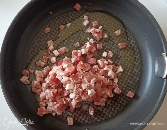 В сковороду налить оливковое масло, выложить бекон и немного его обжарить.