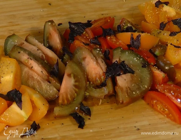 Все помидоры нарезать дольками, посыпать листьями базилика, посолить, поперчить и перемешать.