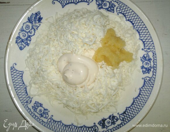 В миске соединить натертые сыр и чеснок, добавить майонез. Перемешать массу до однородности.