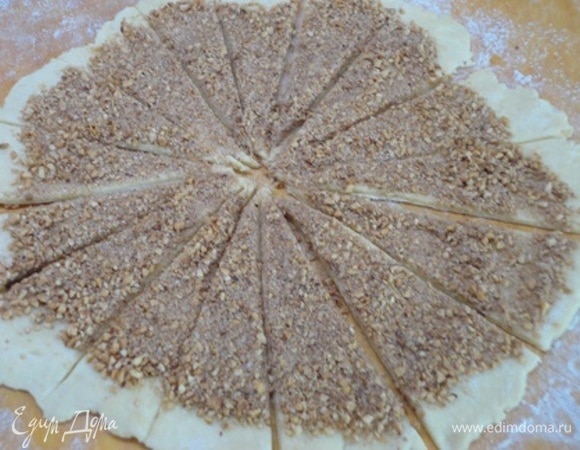 Включите духовку на разогрев до 180°C. Холодное тесто разделите на 3 части. Каждую часть по очереди тонко раскатайте на слегка посыпанной мукой поверхности. Щедро посыпьте орехово-сахарной смесью. Пройдитесь скалкой по ореховой начинке, слегка вдавливая ее в тесто. Так она будет меньше рассыпаться. Разрежьте тесто на 16 частей — сначала пополам, потом на 4 части, потом на 8 и т. д.