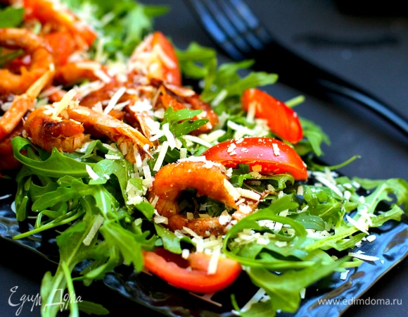 В салатник или тарелку выложить руколу, помидоры черри (я разрезала на 4 сегмента), украсить креветками и пармезаном (я его натерла на мелкой терке, можно нарезать слайсами).