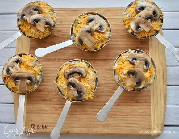 Раскладываю натертый сыр. В качестве украшения можно использовать нарезанные пластинками и обжаренные грибы. Запекаю жюльен в духовке, разогретой до 180°C, до расплавления сыра. Минут 10 будет вполне достаточно.