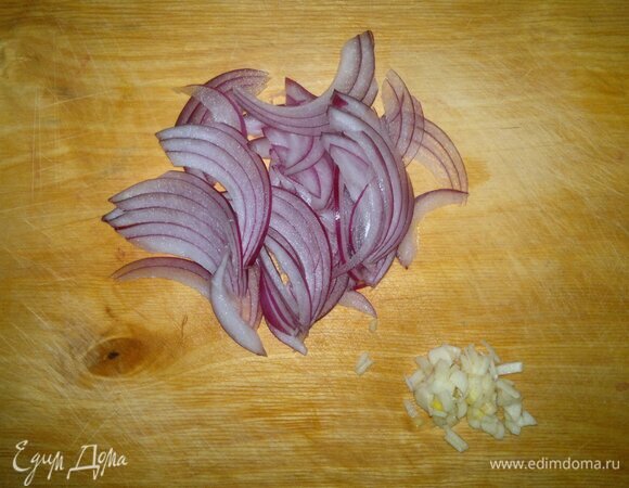 Луковицу очистить и нарезать тонкими полосками. Чеснок почистить, мелко порубить.