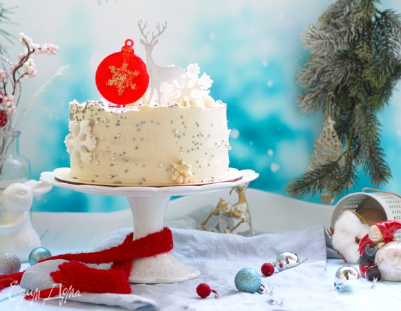 Утром достать торт. Смазать бока и верх кремом, выровнять спатулой. Декорировать по своему усмотрению. Я посыпала сахарными шариками, вырезала снежинки. В центре сделала карамельный шар в силиконовом молде. Олень — готовый топпер.