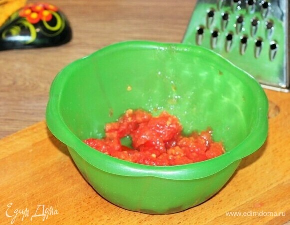 Второй помидор натираем на крупной терке, шкурку удаляем.