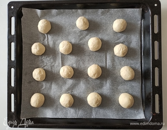 Разделить тесто на небольшие кусочки примерно по 30 г. Скатать шарики. Выложить их на противень, предварительно застелив его пергаментной бумагой.