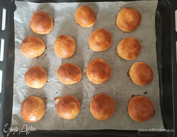 Желток смешать с молоком и смазать верх булочек. Выпекать в предварительно разогретой до 180°C духовке в течение 15–18 минут.