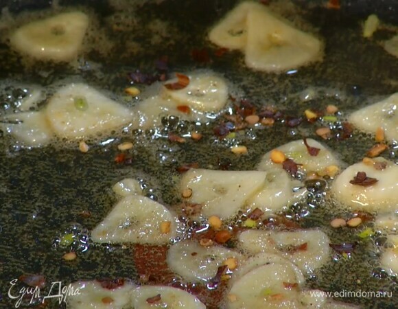Разогреть в сковороде оливковое и сливочное масло и обжарить чеснок до прозрачности, затем посыпать пеперончино.