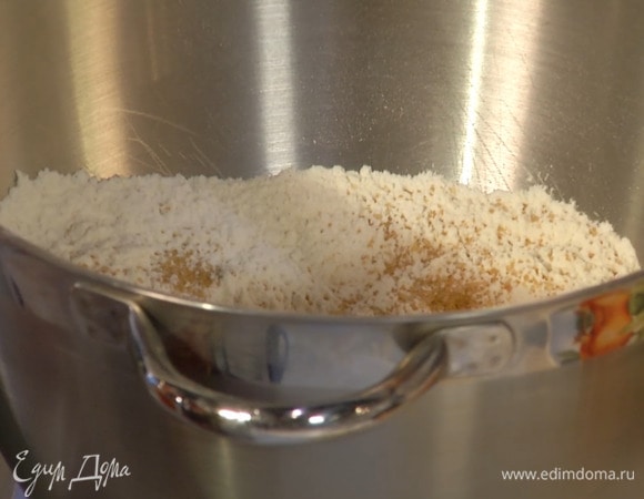 Муку просеять в чашу комбайна, всыпать дрожжи, сахар, все пряности, соль и на невысокой скорости вымешать крюком для теста.