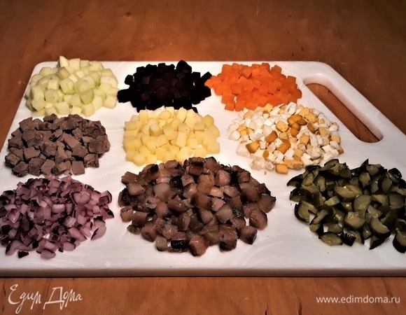 Все ингредиенты — яблоко, свеклу, морковь, мясо, картофель, яйцо, лук, сельдь и огурцы — нарезать мелким кубиком.