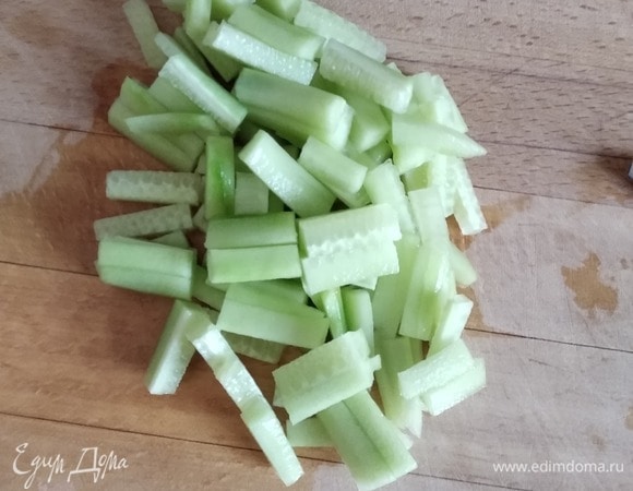 Огурец (у меня один длинноплодный, можно взять 3–4 короткоплодных) нарезать тонкими брусочками. Добавить к капусте и моркови.