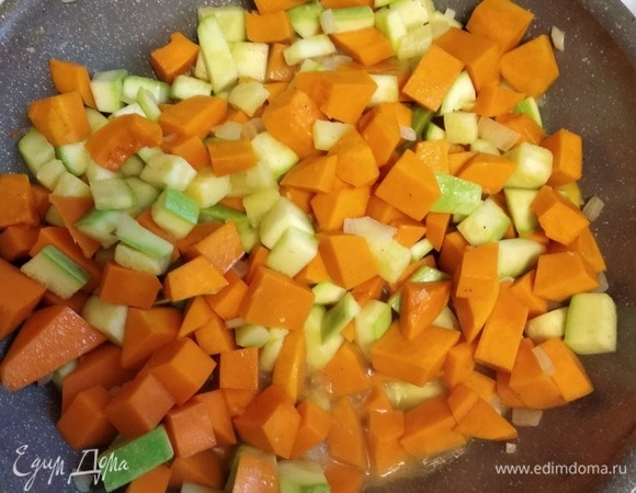 Нарезать кубиком тыкву и кабачок. Добавить к луку и обжаривать 5 минут. Влить вино и готовить минут 10, пока не выпарится алкоголь. Добавить горячий овощной бульон или воду так, чтобы жидкость чуть-чуть покрывала овощи. Варить минут 15–20, до готовности овощей. 