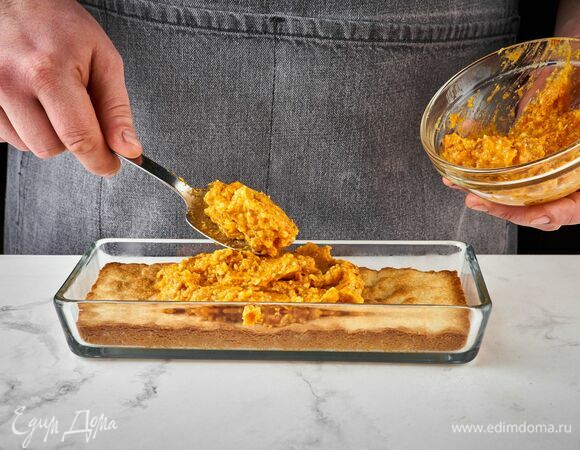 Достаньте из духовки форму с основой, выложите на нее ровный слой начинки из кураги и миндаля.