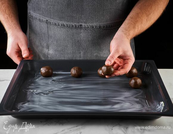 Смажьте противень сливочным маслом. Выложите слепленные из теста шарики на некотором расстоянии друг от друга.