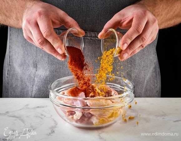 Положите крылышки в глубокую чашу и посыпьте специями.