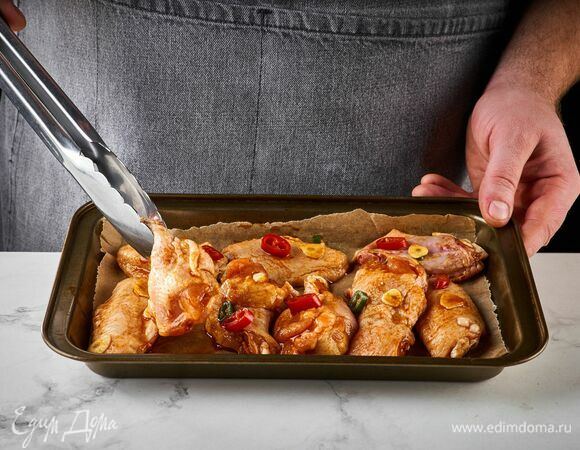 На следующий день крылышки промаринуются, и их можно запекать.<br />
Противень застелите пергаментом, выложите крылья. Запекайте в разогретой до 180°С духовке в течение 1 часа.